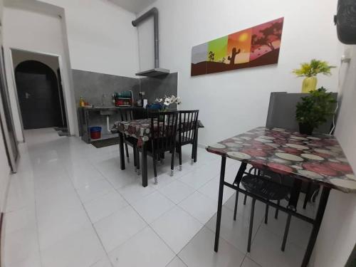 a kitchen and dining room with a table and chairs at Mukhriz 2 Homestay in Kulim