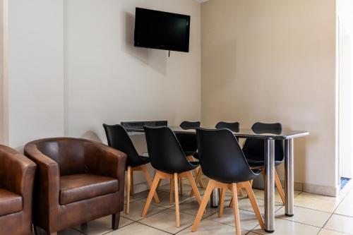 a room with a table and chairs and a television at ATKV Natalia in Kingsburgh