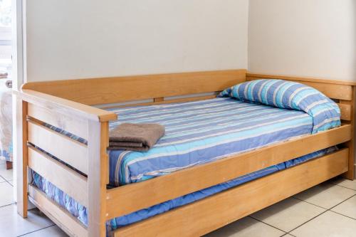 a wooden bunk bed with a blue and white mattress at ATKV Natalia in Kingsburgh