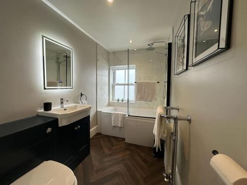 Un baño con inodoro, lavabo y ducha. en Church walk view apartment Filey, en Filey
