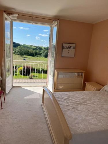 - une chambre avec un lit et une grande porte coulissante en verre dans l'établissement Belle Maison avec vue magnifique , séjour pleine nature gd jardin, à Cressat