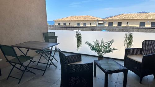 d'un balcon avec des chaises, des tables et une clôture. dans l'établissement Appartement vue mer & plage à pied, à Pietrosella