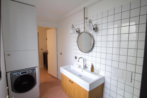 a bathroom with a sink and a mirror on the wall at Bright & Eco-Friendly Wooden Home, A Peaceful Retreat Near Paris in Montreuil