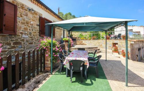 a patio with a table and chairs under an umbrella at Pet Friendly Home In Laureana Cilento in Laureana Cilento