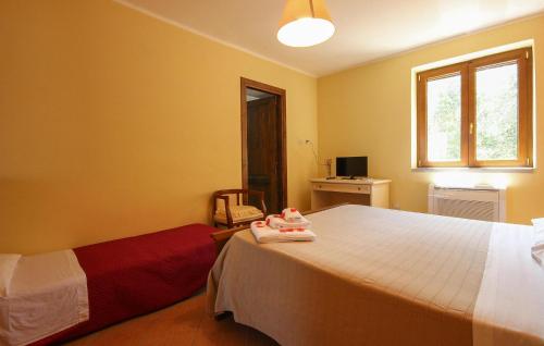 a bedroom with a bed and a window and a chair at Pet Friendly Home In Laureana Cilento in Laureana Cilento