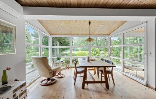 a dining room with a table and chairs and windows at Nice Home In Faxe Ladeplads With Wifi in Fakse Ladeplads