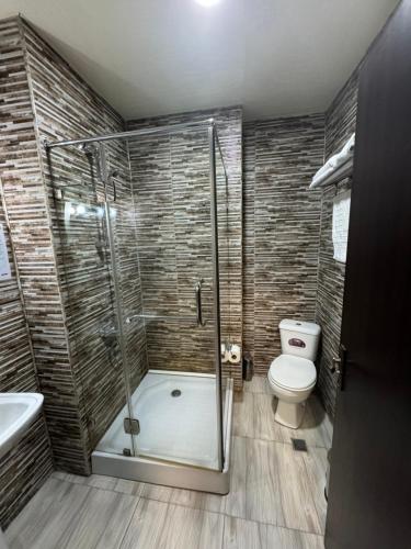 a bathroom with a shower and a toilet at Pirosmani Mini Hotel in Batumi