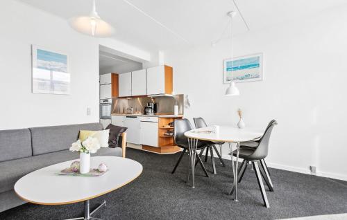 a living room with a couch and tables and a kitchen at Fanø Bad, Lejl 51 in Fanø