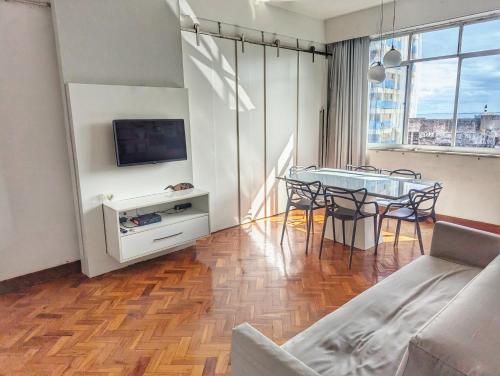 a living room with a table and a tv at Apartamentos na BARRA com VISTA MAR, a 1 minuto da praia e do Circuito do Carnaval - SEAVIEW PRIVATE APARTMENTS in Salvador