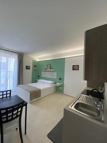 a room with a bed and a kitchen with a sink at Le Buguse suite apartment in Lecce