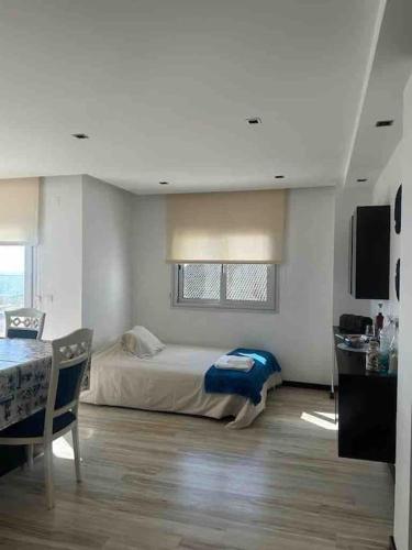 a bedroom with a bed and a table and a television at Apartamento Praia do Pedrogão com vista mar in Leiria