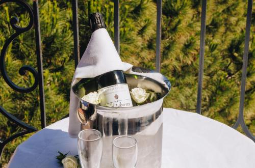 a bottle of wine sitting in a bucket on a table at Hôtel Liberata & Spa in LʼÎle-Rousse