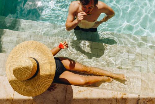 a man and a woman in a swimming pool at Hôtel Liberata & Spa in LʼÎle-Rousse
