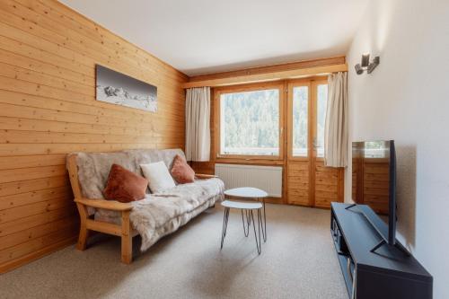 a living room with a couch and a tv at Charmant duplex à 3min des remontées mécaniques in Grimentz