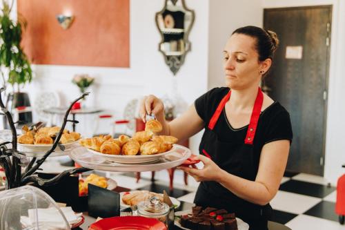 a woman is holding a plate of food at Hôtel Liberata & Spa in LʼÎle-Rousse