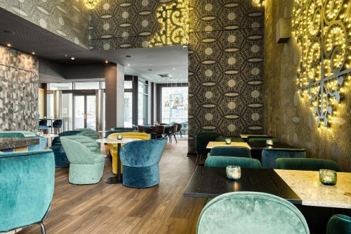 a restaurant with blue chairs and tables and tablesktop at Motel One Brussels in Brussels