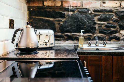 a tea kettle sitting on top of a stove in a kitchen at Willows, 3 Bed Cottage with Spacious Kitchen in Lisburn