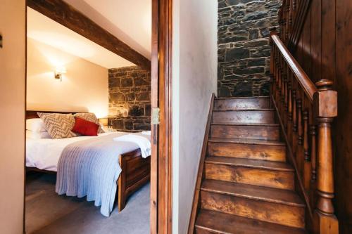 a bedroom with a bed and a staircase in a room at Willows, 3 Bed Cottage with Spacious Kitchen in Lisburn