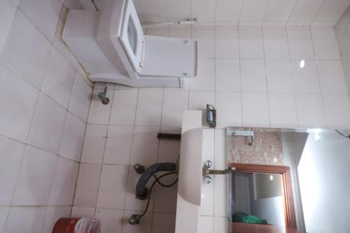 a small bathroom with a refrigerator and a mirror at PAK Heritage Hotel in Lahore