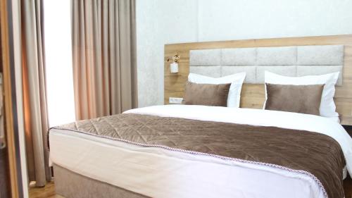 una camera da letto con un letto grande con testiera in legno di Grand Shosh Hotel a Tashkent