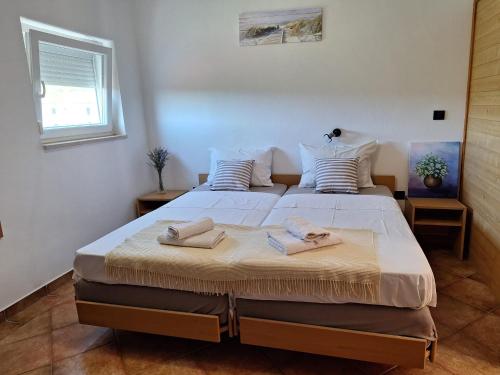 a bedroom with a large bed with towels on it at Loft Apartman in Krk