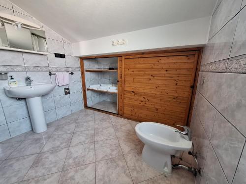 a bathroom with a sink and a toilet and a mirror at Loft Apartman in Krk