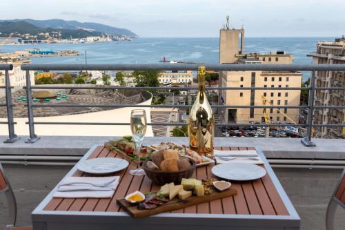 stół z jedzeniem i kieliszek wina na balkonie w obiekcie Allegroitalia La Spezia 5 Terre w mieście La Spezia