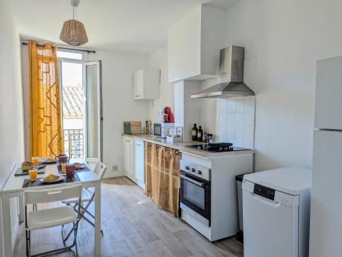- une cuisine avec des appareils électroménagers blancs et une table dans l'établissement Appartement 3 chambres avec billard - centre, à Béziers