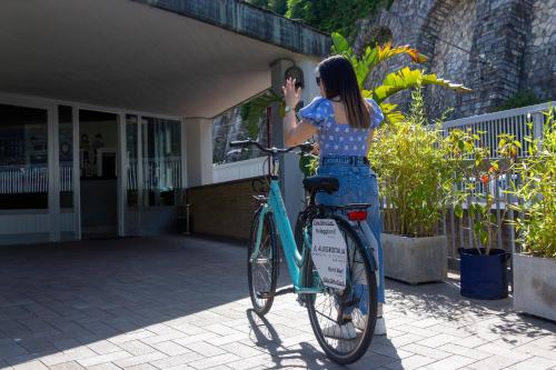 a woman is standing next to a bike at Allegroitalia La Spezia 5 Terre in La Spezia