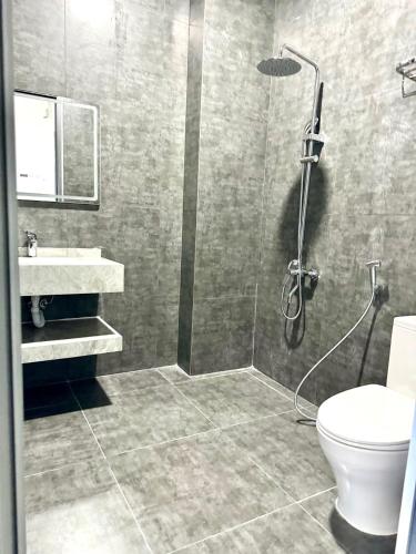 a bathroom with a shower and a toilet and a sink at Green House - Căn hộ có bếp riêng in Da Lat