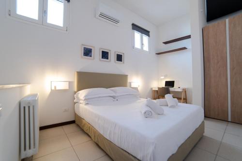 a bedroom with a large bed with white sheets and pillows at Coco Places Apartments Santa Maria Novella, Centro Storico in Florence