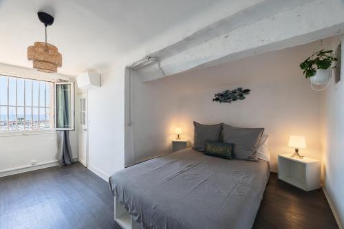 une chambre avec un grand lit et deux lampes dans l'établissement Le plaisir des yeux !, à Cassis