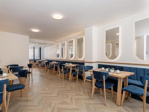 a dining room with tables and blue chairs at Miss Marrone City Hotel in Chania Town