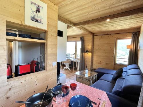 un salon avec un canapé bleu et une table dans l'établissement Appartement 3 pièces + cabine à Megève, 6 couchages, proche pistes et téléphérique - FR-1-597-170, à Megève