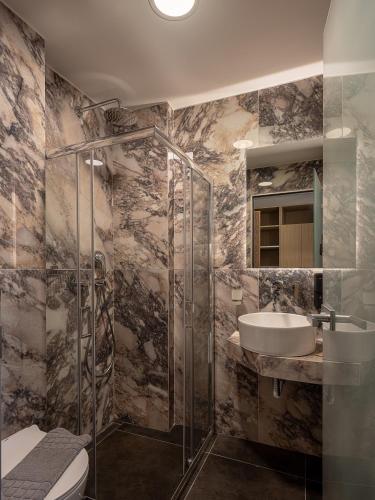 a bathroom with a sink and a shower and a toilet at Miss Marrone City Hotel in Chania Town