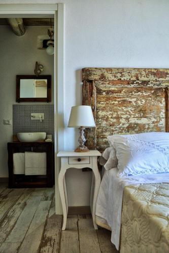 a bedroom with a bed and a table with a lamp at La Casa della Filanda in Belmonte Calabro