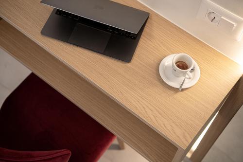 a table with a cup of coffee on a plate at Miss Marrone City Hotel in Chania Town