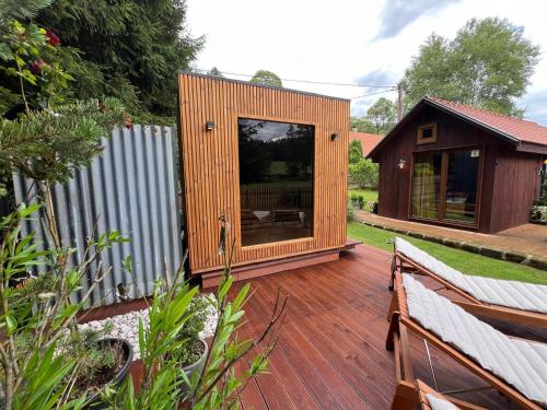 a small wooden house on a wooden deck at Tiny House Všemily in Jetřichovice