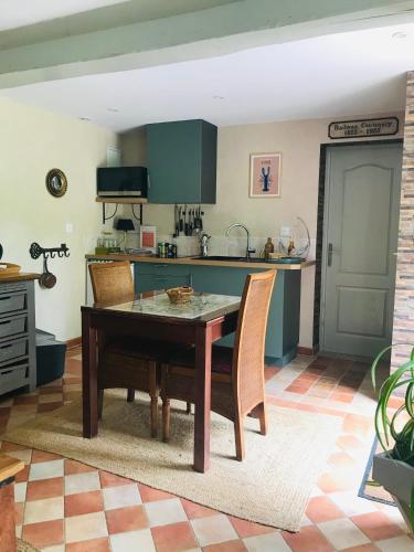 une cuisine avec une table et des chaises dans une pièce dans l'établissement BnB Golden Delicious for 2 in Normandy, à Les Champeaux