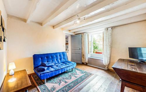un salon avec un canapé bleu et une télévision dans l'établissement Gîte Au Naturel, à Nieuil