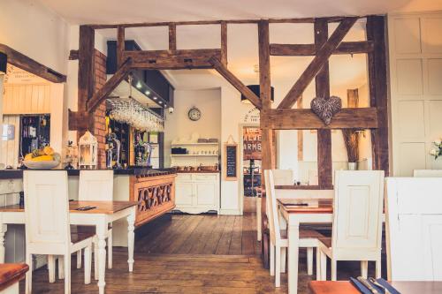 comedor con mesas de madera y sillas blancas en The Salwey Arms, en Ludlow