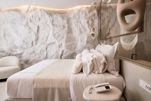 a hotel room with a bed with a phone on it at Ethereum Mykonos in Mýkonos City