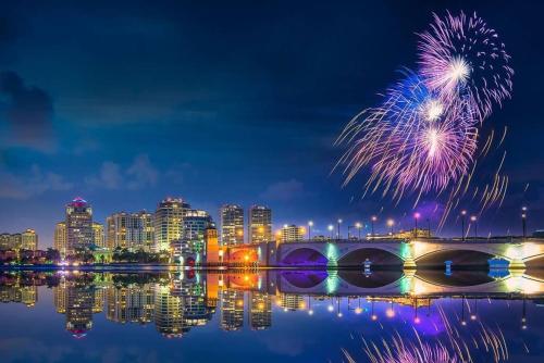 a fireworks display over a city with a bridge and water at 4br Private Guest Suite Pool Pga Beaches in Palm Beach Gardens