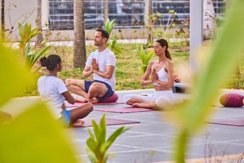 a group of people sitting in a yoga class at Riu Palace Mauritius - All Inclusive - Adults Only in Le Morne