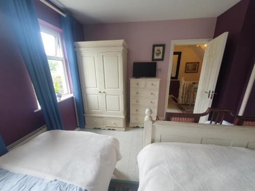 a bedroom with a bed and a dresser and a mirror at The Retreat Guest Rooms in Carlingford