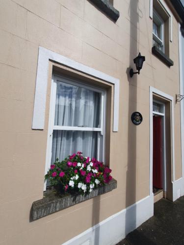 a window with flowers in a window box on a building at The Retreat Guest Rooms in Carlingford