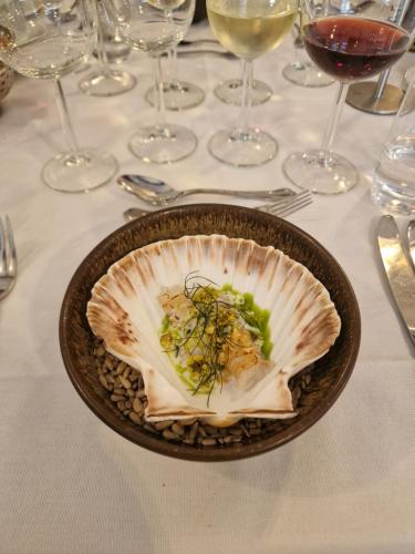 a bowl of food on a table with wine glasses at Filskov Kro in Grindsted