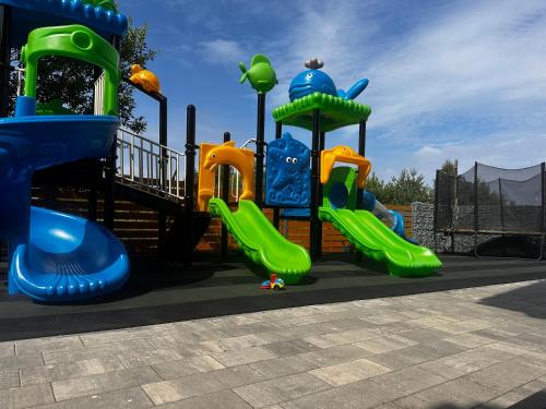 a playground with a slide in a park at Domki Złote Piaski Kryty Basen Sauna Jacuzzi in Jastrzębia Góra