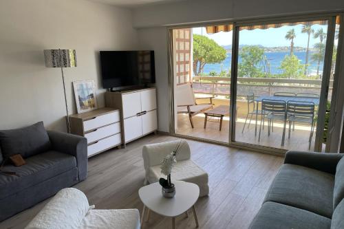 un salon avec un canapé et une télévision et un balcon dans l'établissement Studio with large balcony - sea view, à Bandol
