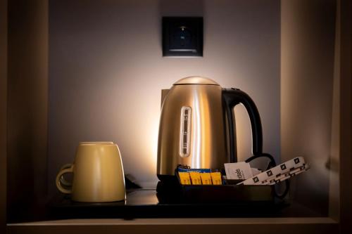 a tea kettle and a candle on a table at Acta The Clover in Porto